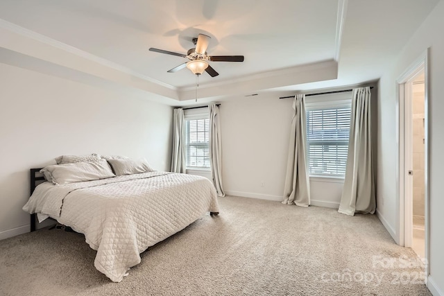 bedroom featuring ceiling fan, multiple windows, connected bathroom, and a raised ceiling