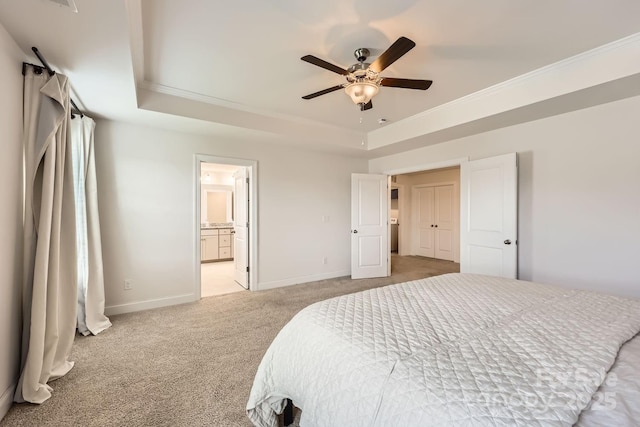 carpeted bedroom featuring a raised ceiling, ceiling fan, ensuite bathroom, and ornamental molding