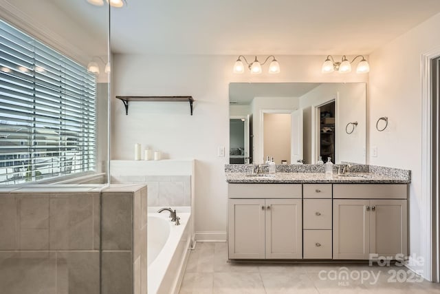 bathroom with vanity, tile patterned flooring, and a washtub