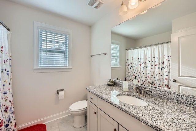 bathroom with toilet, vanity, plenty of natural light, and tile patterned floors