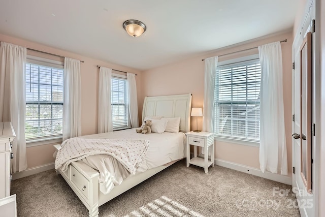 bedroom featuring light colored carpet and multiple windows