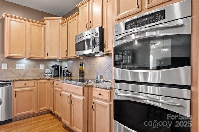 kitchen with decorative backsplash, light stone counters, light hardwood / wood-style flooring, and stainless steel appliances