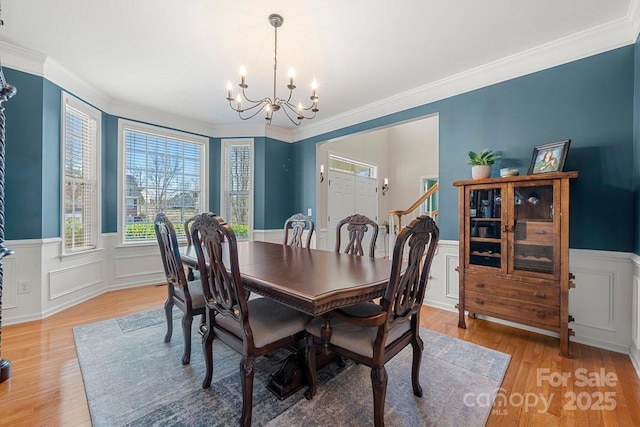 dining room featuring ornamental molding, a notable chandelier, and light wood-type flooring