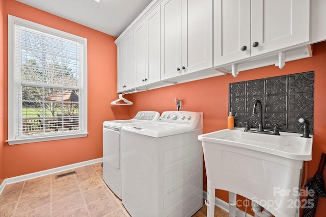 laundry room featuring cabinets, independent washer and dryer, plenty of natural light, and sink