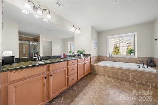 bathroom featuring tile patterned floors, vanity, and plus walk in shower