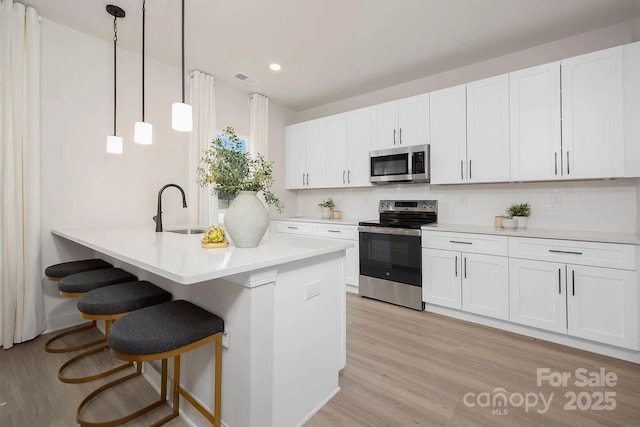 kitchen featuring white cabinetry, sink, and appliances with stainless steel finishes