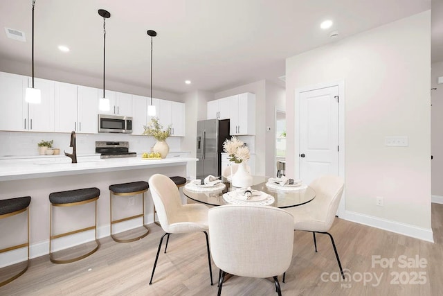 dining space with light hardwood / wood-style floors