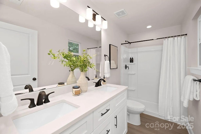 bathroom with walk in shower, hardwood / wood-style flooring, vanity, and toilet