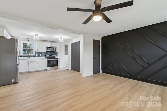 kitchen featuring light hardwood / wood-style flooring, decorative backsplash, ceiling fan, white cabinetry, and stainless steel appliances