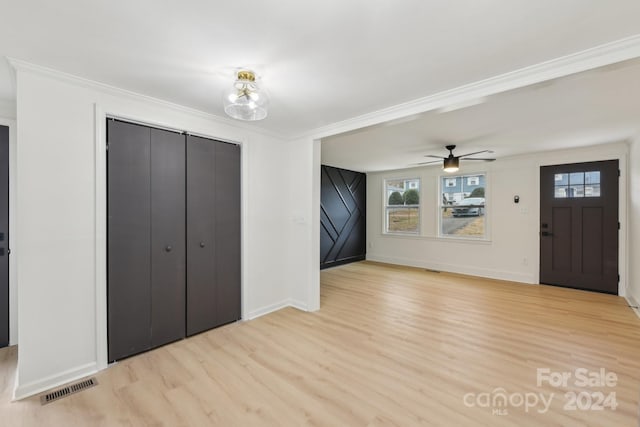 foyer with light hardwood / wood-style floors, ceiling fan, and ornamental molding