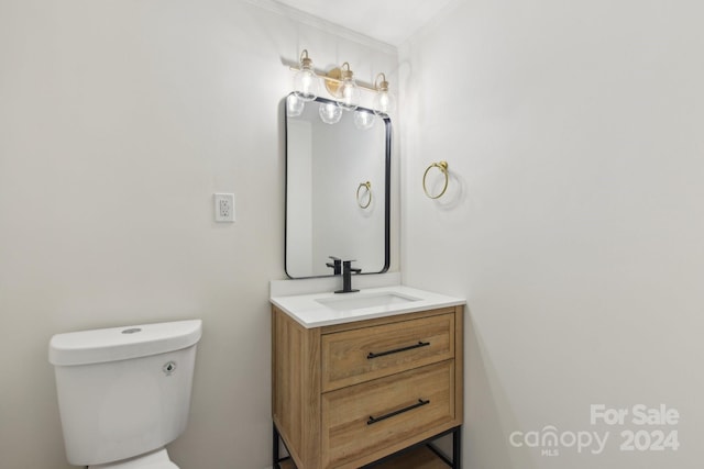 bathroom featuring vanity, toilet, and ornamental molding