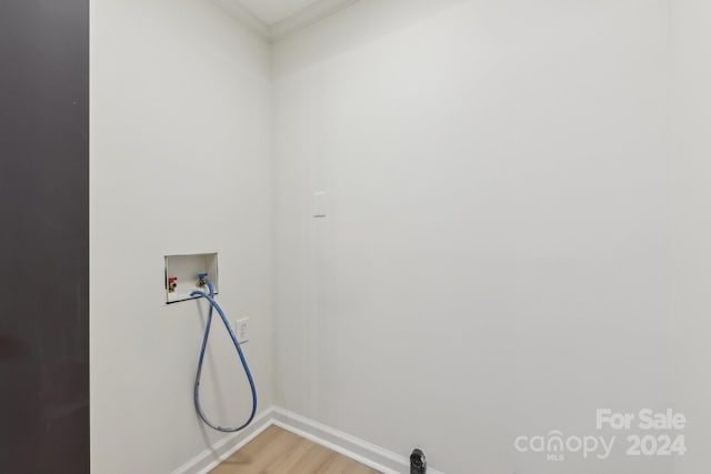 laundry area featuring hardwood / wood-style floors, ornamental molding, and washer hookup