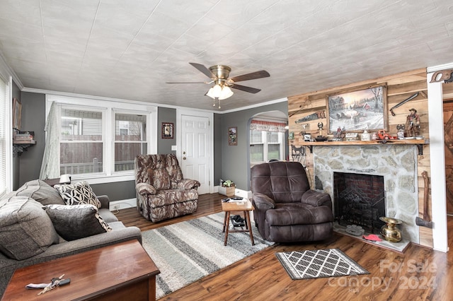 living room featuring ceiling fan, a fireplace, ornamental molding, and hardwood / wood-style flooring