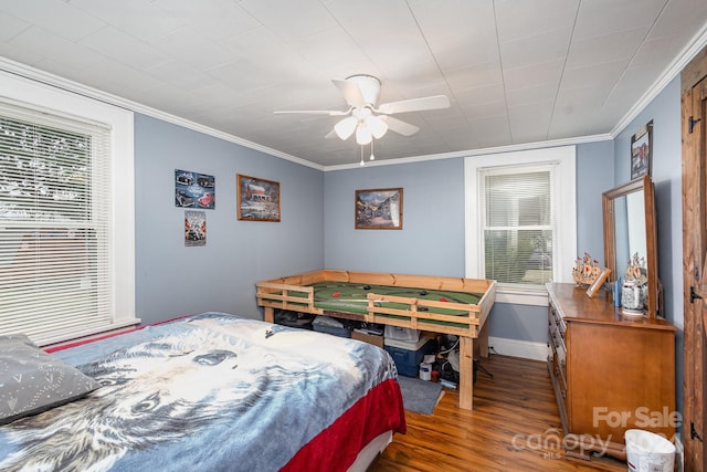 bedroom with ceiling fan, dark wood-type flooring, and ornamental molding