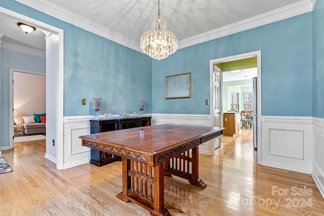 dining space featuring ornamental molding, a chandelier, and light wood-type flooring