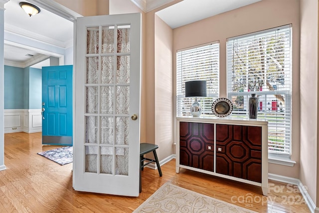 entryway featuring light hardwood / wood-style flooring, crown molding, and a healthy amount of sunlight