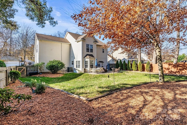 rear view of house with a patio, central AC, and a lawn