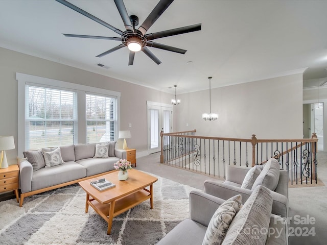 carpeted living room featuring ceiling fan with notable chandelier and ornamental molding