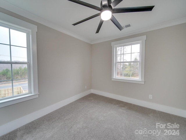 empty room with carpet flooring, ceiling fan, and ornamental molding