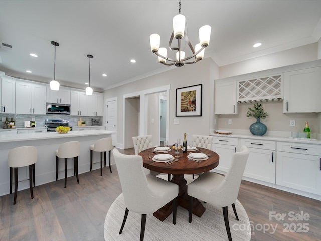 dining space featuring dark wood-style floors, recessed lighting, crown molding, and an inviting chandelier