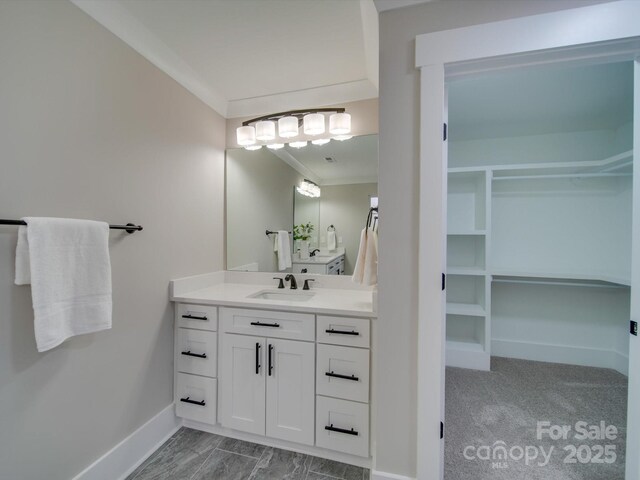 1304 Pleasant Plains Rd, Matthews, NC 28105 - bathroom featuring vanity, a spacious closet, ornamental molding, and baseboards