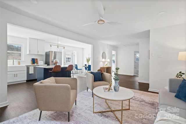 living room with sink, ceiling fan, plenty of natural light, and dark hardwood / wood-style floors