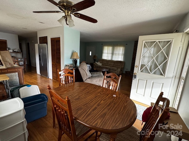 dining space featuring a textured ceiling, ceiling fan, and dark hardwood / wood-style floors