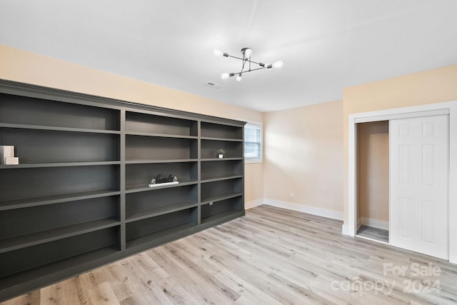 interior space featuring an inviting chandelier, a closet, and light hardwood / wood-style flooring