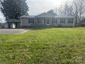 single story home featuring a storage unit and a front lawn