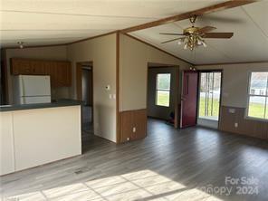 interior space featuring light wood-type flooring, lofted ceiling with beams, and a wealth of natural light