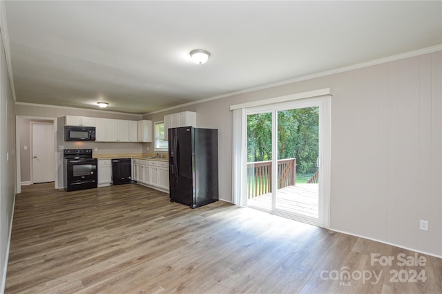 kitchen featuring white cabinets, light hardwood / wood-style floors, crown molding, and black appliances