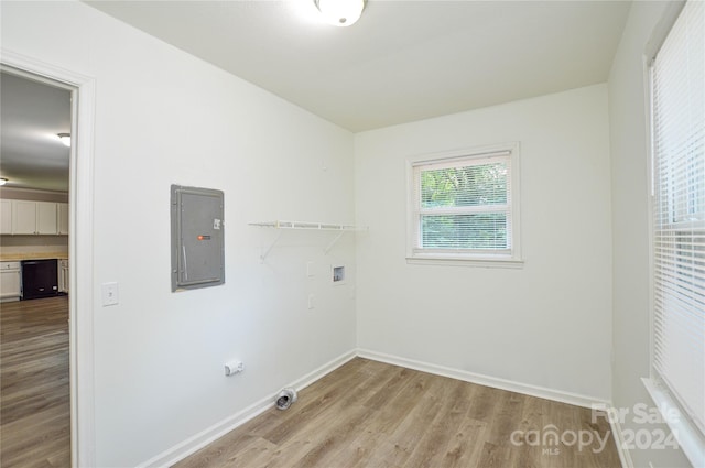 laundry room featuring electric panel, washer hookup, and light wood-type flooring