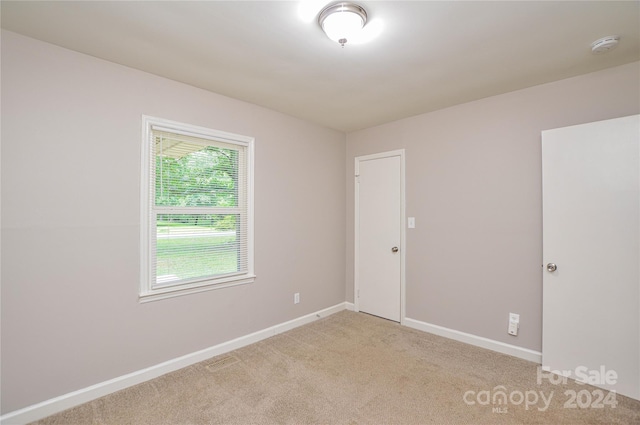 unfurnished room with light carpet