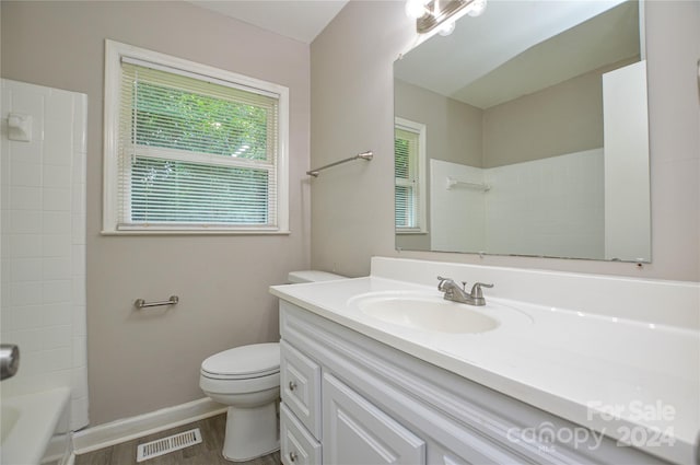 full bathroom with washtub / shower combination, vanity, wood-type flooring, and toilet