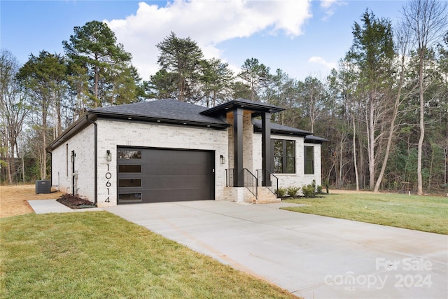 view of front of house featuring central AC, a front lawn, and a garage