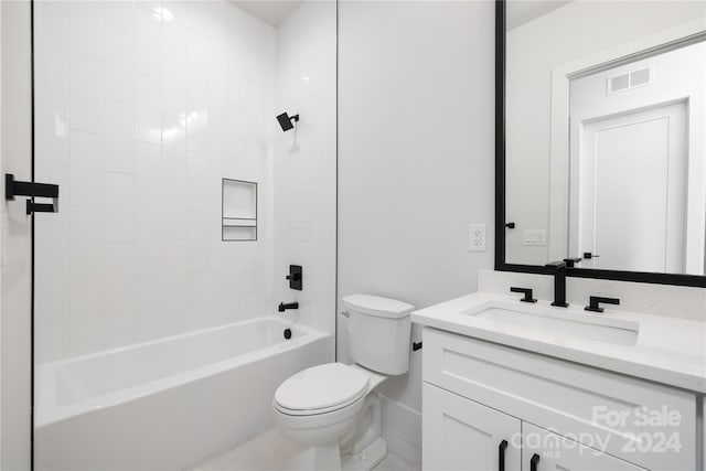 full bathroom featuring vanity, tiled shower / bath combo, and toilet