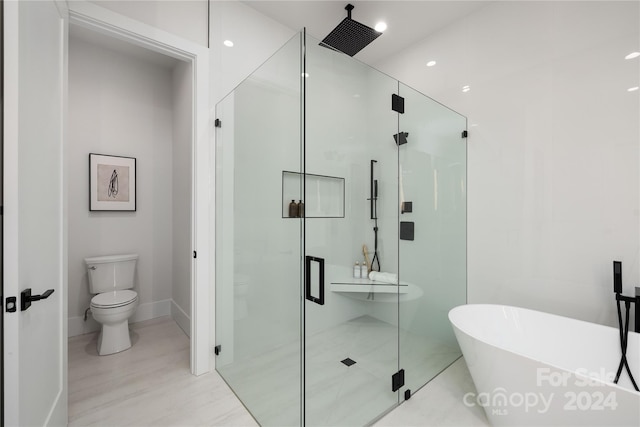 bathroom with toilet and shower with separate bathtub