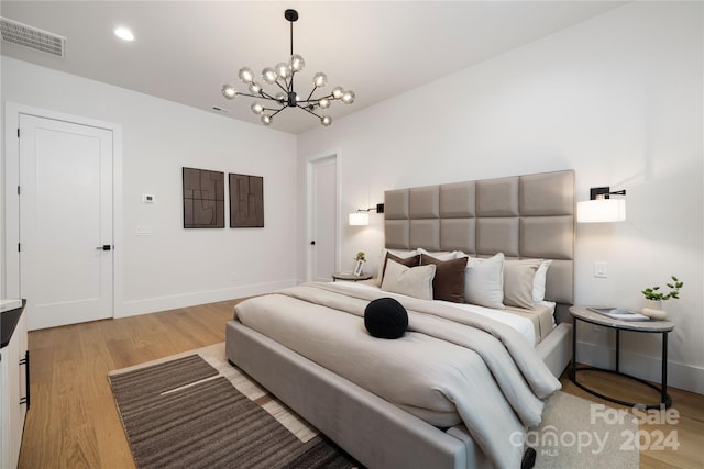 bedroom featuring a chandelier and light hardwood / wood-style floors