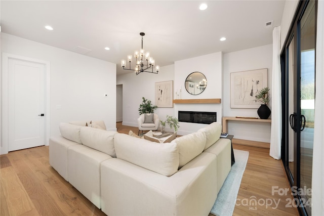 living room featuring an inviting chandelier and light hardwood / wood-style flooring