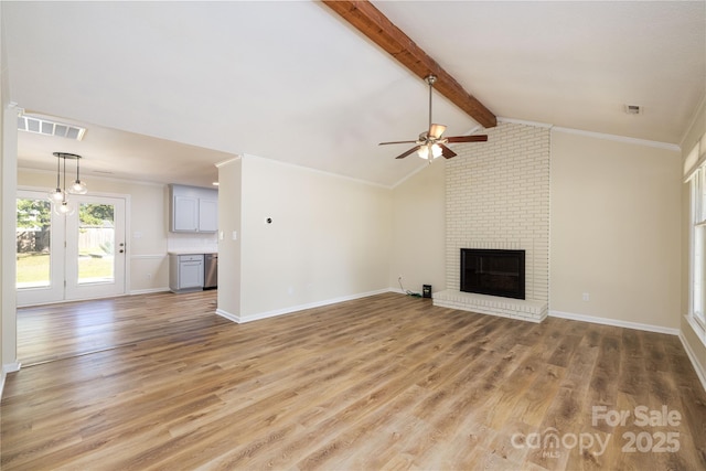 unfurnished living room featuring lofted ceiling with beams, wood-type flooring, ornamental molding, ceiling fan, and a brick fireplace