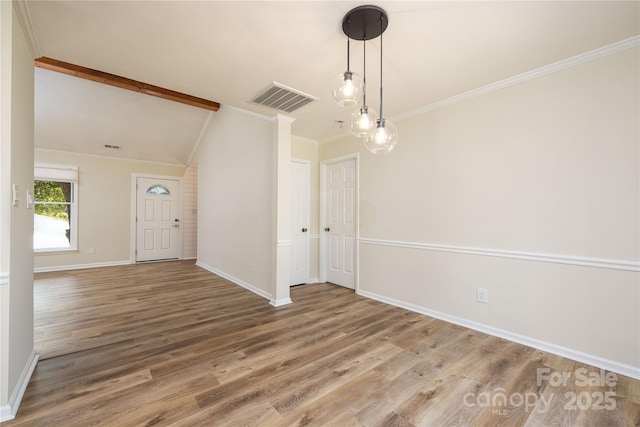 unfurnished dining area featuring hardwood / wood-style flooring, ornamental molding, and lofted ceiling with beams