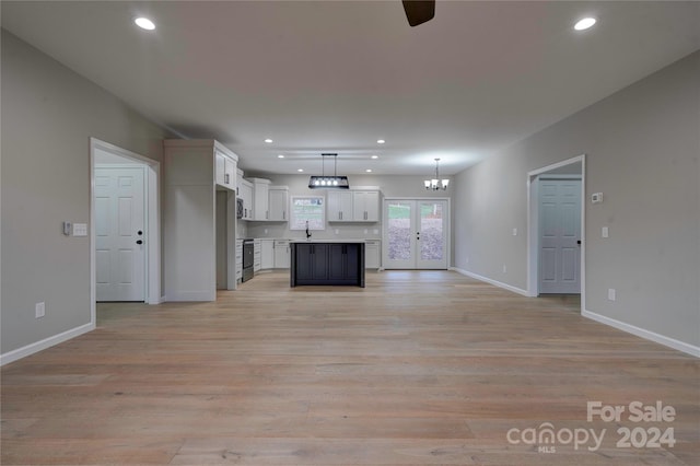 unfurnished living room featuring french doors, light hardwood / wood-style floors, and sink