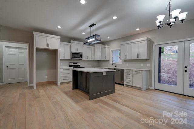 kitchen with hanging light fixtures, a center island, stainless steel appliances, and a wealth of natural light