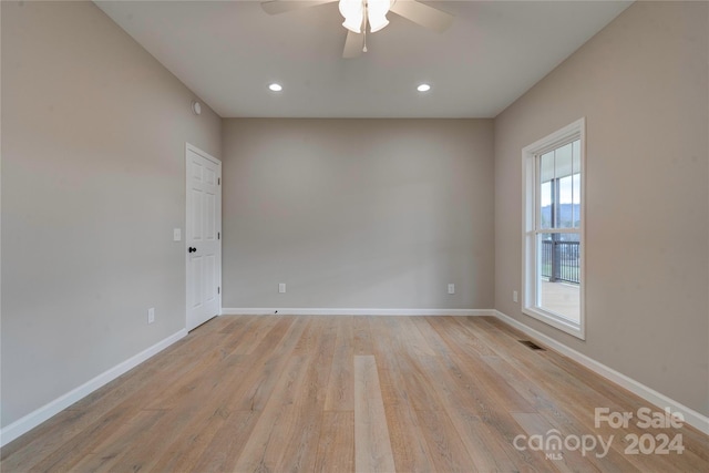 empty room with ceiling fan and light hardwood / wood-style flooring