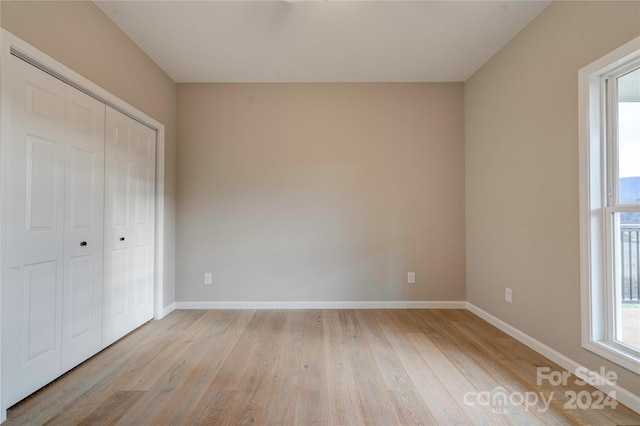 unfurnished bedroom with a closet and light hardwood / wood-style floors