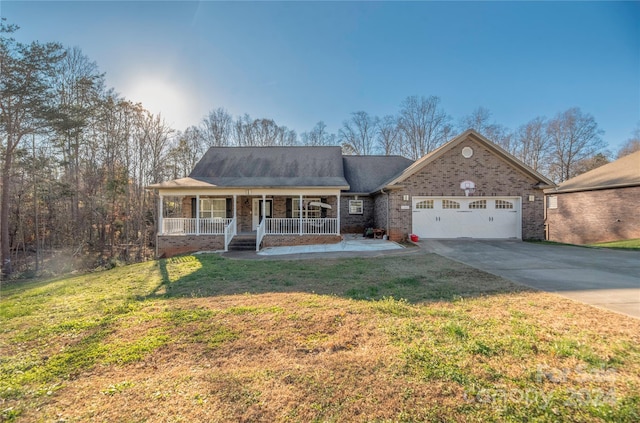 view of front of home featuring a garage, covered porch, and a front yard