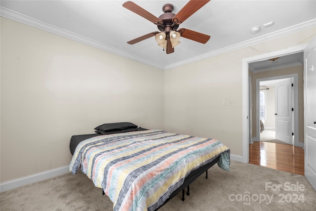 carpeted bedroom featuring ceiling fan and crown molding