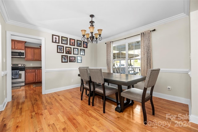 dining room with a chandelier, light wood-type flooring, and ornamental molding