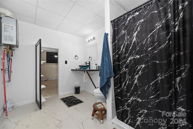 bathroom featuring a shower with curtain, a drop ceiling, and toilet