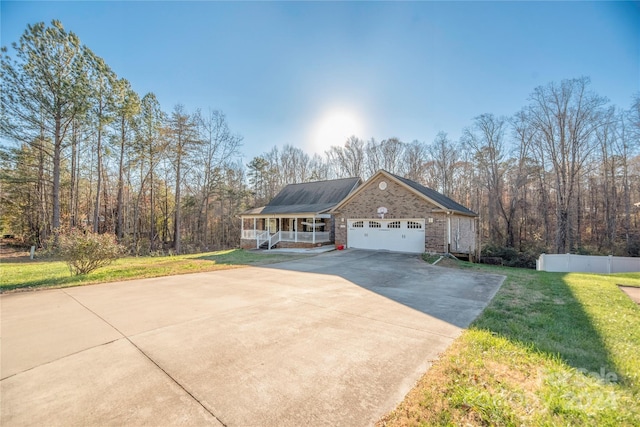 view of front of home featuring a garage, covered porch, and a front lawn